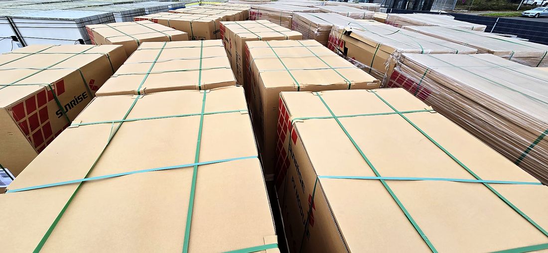 Viele gegurtete Kartons mit Solarmodulen auf dem Lagerplatz